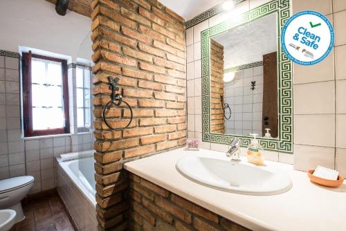 a bathroom with a sink and a brick wall at Horta da Quinta in Mértola