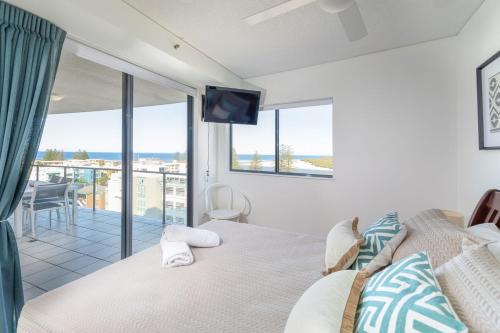 a bedroom with a bed and a view of the ocean at The Waterford Prestige Apartments in Caloundra