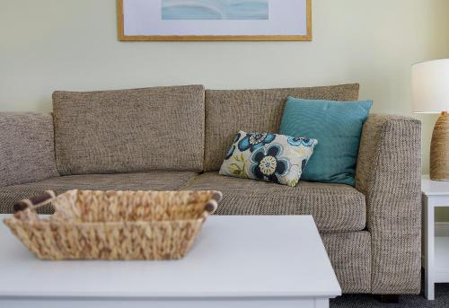 a living room with a couch and a table at Ettalong Beach Luxury Apartments in Ettalong Beach