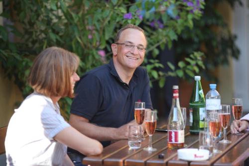 a man and a woman sitting at a table with wine glasses at Ferienhof Uhudler-Arkaden in Stegersbach