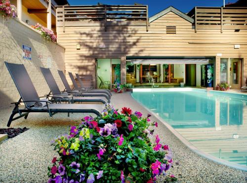 a pool with chairs and flowers next to a building at GetAways at Eagle Point Resort in Vail