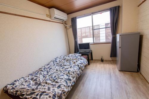 a bedroom with a bed and a desk and a window at Chiba Green hills Inage #8Mx in Chiba