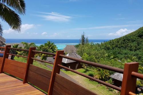 une terrasse en bois avec vue sur l'océan dans l'établissement Villa Anuanua by Tahiti Homes, à Papetoai