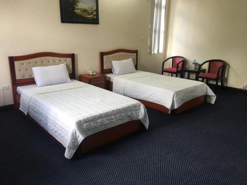 a hotel room with two beds and two chairs at Thien Anh Hotel in Hai Phong