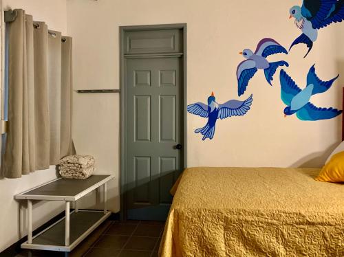 a bedroom with a bed with blue birds on the wall at Hotel y Arte Antigua by Amazing Guatemala Travel in Antigua Guatemala