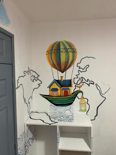 a house in a boat and a hot air balloon on a wall at Hotel y Arte Antigua by Amazing Guatemala Travel in Antigua Guatemala