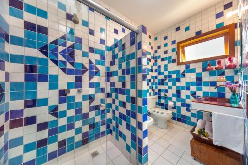 a bathroom with blue and white tiles on the wall at Charm Bahia Residencias in Arraial d'Ajuda