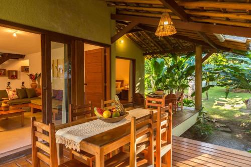 a wooden dining room with a table and chairs at Charm Bahia Residencias in Arraial d'Ajuda