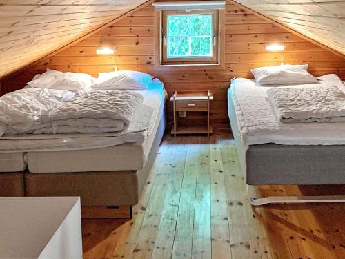 two beds in a wooden cabin with a window at 8 person holiday home in jørpeland-By Traum in Jørpeland