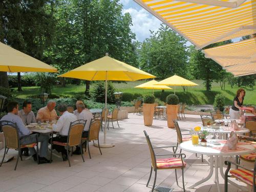 a group of people sitting at tables with yellow umbrellas at Schwarzwaldhotel Oberwiesenhof in Seewald