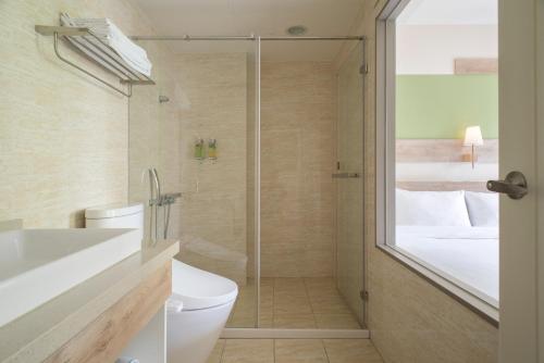 a bathroom with a toilet and a glass shower at Hotel Kuei in Taichung