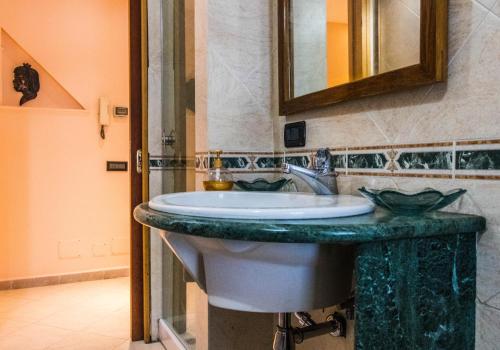 a bathroom with a sink and a mirror at Carla Suite Sorrento in Sorrento