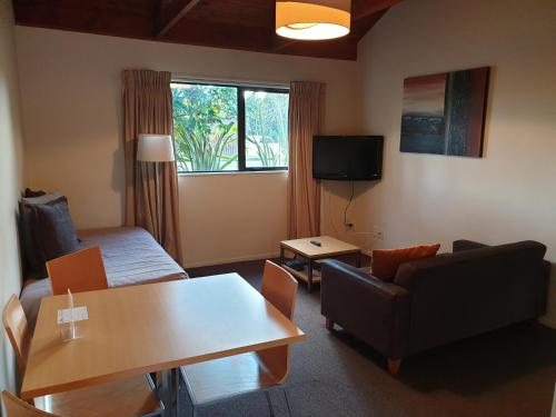 奧阿庫尼的住宿－霍比特汽車旅館，客厅配有沙发和桌子