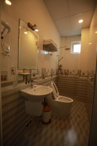 a bathroom with a sink and a tub and a toilet at VES - PA Luxury Hotel in Da Lat