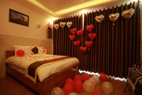 a bedroom with a bed with red and white balloons at VES - PA Luxury Hotel in Da Lat