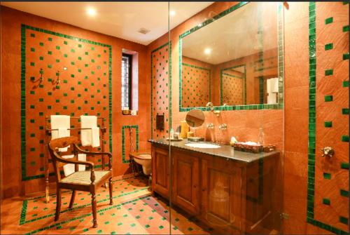 a bathroom with a sink and a toilet and a chair at Chittoor Kottaram Royal Mansion - A CGH Earth SAHA Experience in Cochin