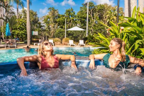 two women laying in the pool at a resort at The Oasis Apartments and Treetop Houses in Byron Bay