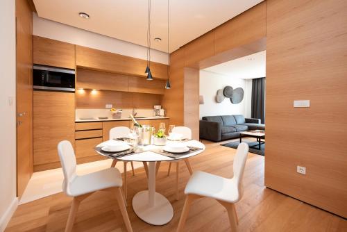 a dining room and living room with a table and chairs at Beachfront Apartment Rosa del Mar Jardin in Mošćenička Draga