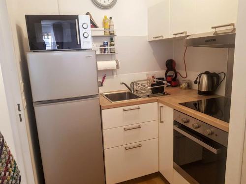 une petite cuisine avec un réfrigérateur et un micro-ondes dans l'établissement Fréjus plage, à Fréjus