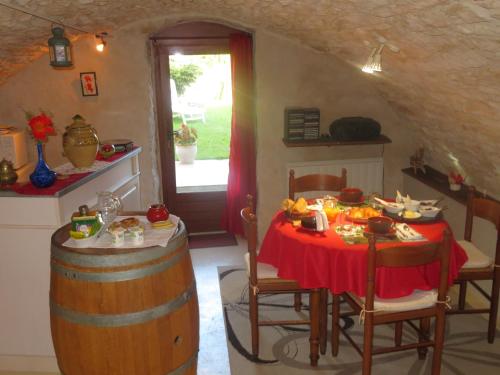 Murmure des buis في Corveissiat: غرفة طعام مع طاولة وبرميل للنبيذ