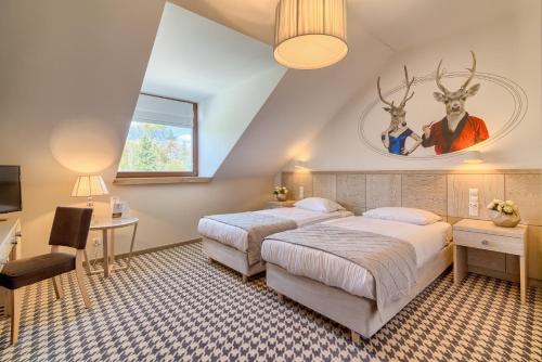 a bedroom with two beds and a desk and a tv at Hanza Pałac Wellness & SPA in Warlubie