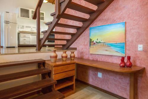 a staircase in a kitchen with a painting on the wall at Charm Bahia Residencias in Arraial d'Ajuda