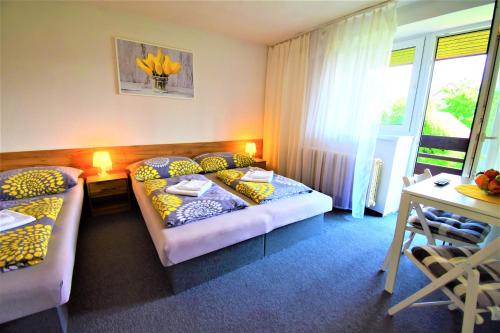 una camera d'albergo con due letti e una scrivania di Villa Vanilla a Liptovský Mikuláš