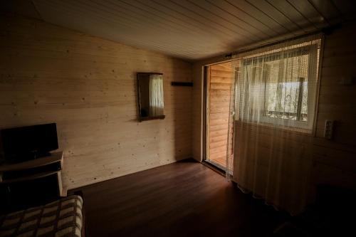 an empty room with a window and a television at Sadyba u Gansa in Svityazʼ