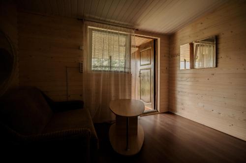 a room with a table and a chair and a window at Sadyba u Gansa in Svityazʼ