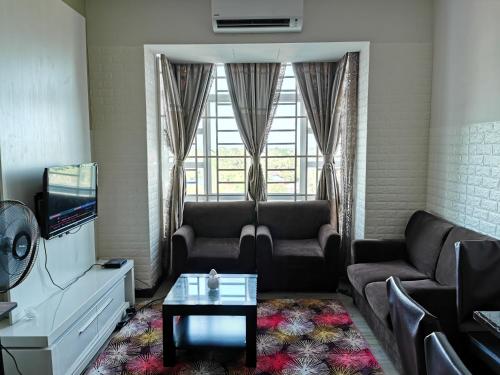a living room with a couch and a tv at Ilham Homestay @ Anjung Vista Kubang Kerian in Kota Bharu