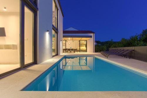 a swimming pool in the backyard of a house at Casa Bela in Klimno