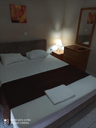 a bedroom with a bed and a dresser with a mirror at Hotel-Apartments La Strada in Tycherón