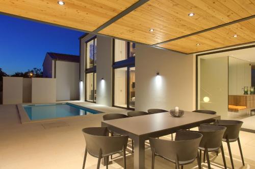a patio with a table and chairs and a swimming pool at Casa Forma in Klimno