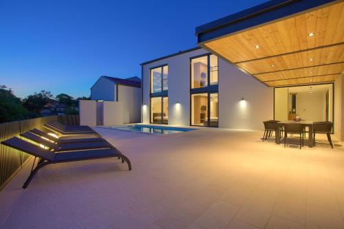 a patio of a house with a bench and a table at Casa Forma in Klimno