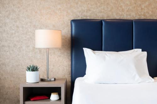 a bed with a blue headboard and a table with a lamp at Waterfront in Sliema