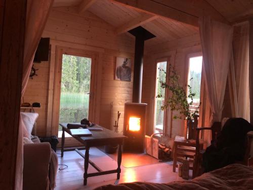 a living room with a table and a fireplace at Rustika strandstugor utanför Rättvik in Rättvik