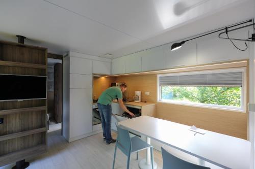 a man standing in a kitchen with a table at Camping Baalse Hei in Turnhout