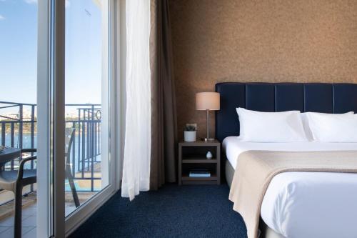 
a hotel room with a bed and a window at Waterfront in Sliema
