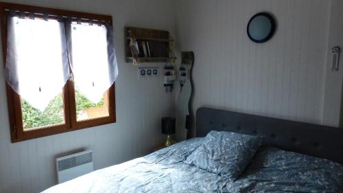 une chambre avec un lit et une fenêtre dans l'établissement Chalet Soulacais avec piscine, à Soulac-sur-Mer