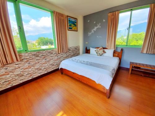 a bedroom with a bed in a room with windows at Pulicity Villa B&B in Puli