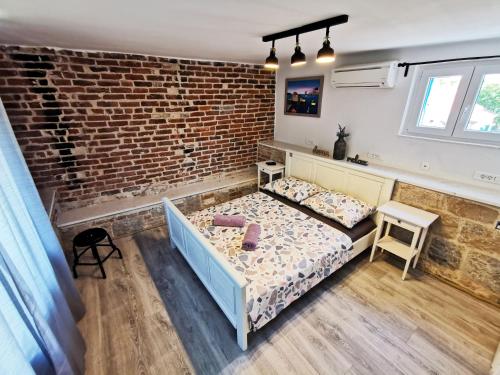 a bedroom with a bed and a brick wall at CroBeauty Villa in Split