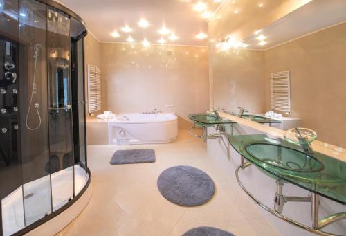 ウストロニエ・モルスキエにあるMurena Hotel i Restauracjaのバスルーム(ガラスの洗面台2つ、バスタブ付)