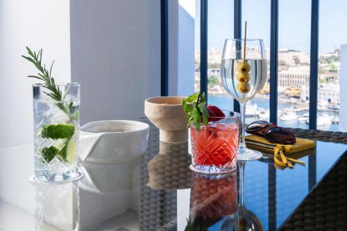 a table with three vases and a wine glass at Waterfront in Sliema