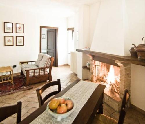 a living room with a table and a fireplace at Borgo San Valentino in Arrone