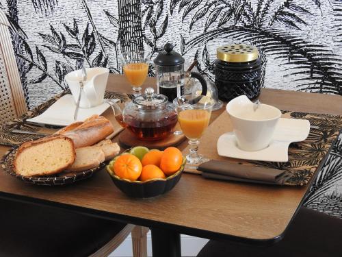 une table avec un petit-déjeuner composé de pain et de jus d'orange dans l'établissement Villa Madura, à Saint-Michel-Chef-Chef