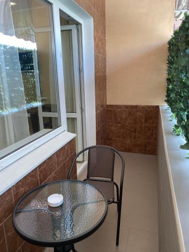 a glass table and a chair on a balcony at Міні-готель "Кімната Комфорт" in Odesa
