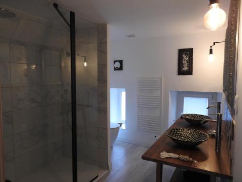 La salle de bains est pourvue d'une douche et d'une table en bois. dans l'établissement Villa Madura, à Saint-Michel-Chef-Chef