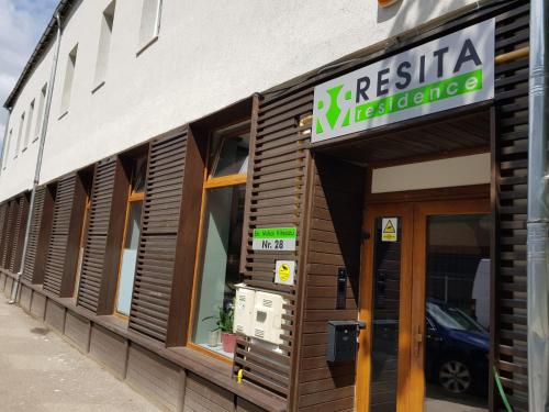 a restaurant with a sign on the side of a building at Resita Residence Sauna Apartment in Reşiţa