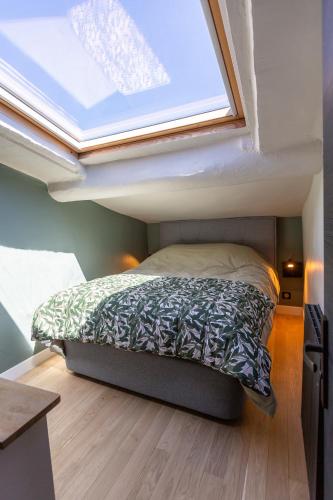 Ce lit se trouve dans une petite chambre dotée d'une lucarne. dans l'établissement DUPLEX MIRABEAU - Roof terrace with panoramic view, à Aix-en-Provence