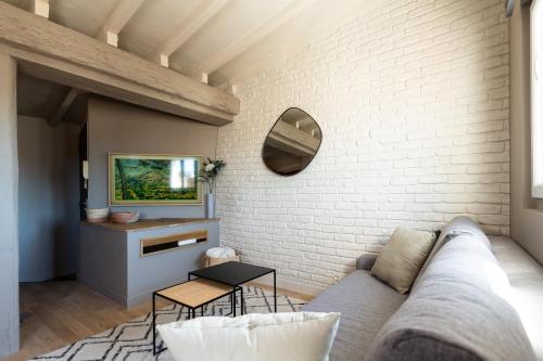 a living room with a couch and a white brick wall at DUPLEX MIRABEAU - Roof terrace with panoramic view in Aix-en-Provence